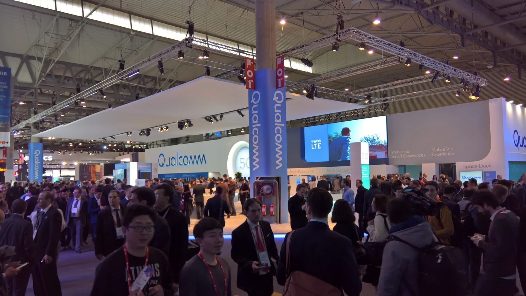 Stand de Qualcomm terminado y en funcionamiento con visitantes en la feria.